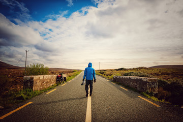 Bicycle touring cyclist is walking to his bicycle