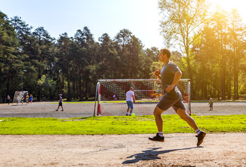 Athlete running on track near football field