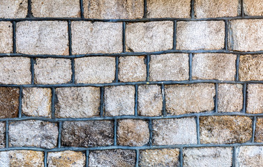 Weathered grey stone wall as background texture
