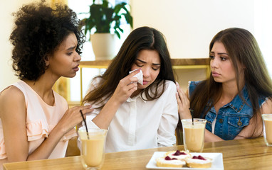 Two friends cheering up young depressed girl