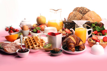 Huge healthy breakfast on table with coffee, orange juice, fruits, waffles and croissants. Good morning concept.