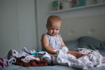 Fototapeta premium big pile of clean clothes and baby playing