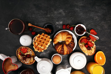 Huge healthy breakfast on table with coffee, orange juice, fruits, waffles and croissants. Good morning concept.