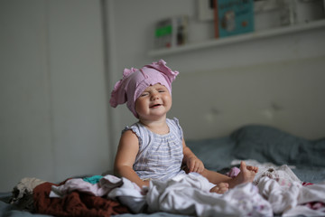 big pile of clean clothes and baby playing