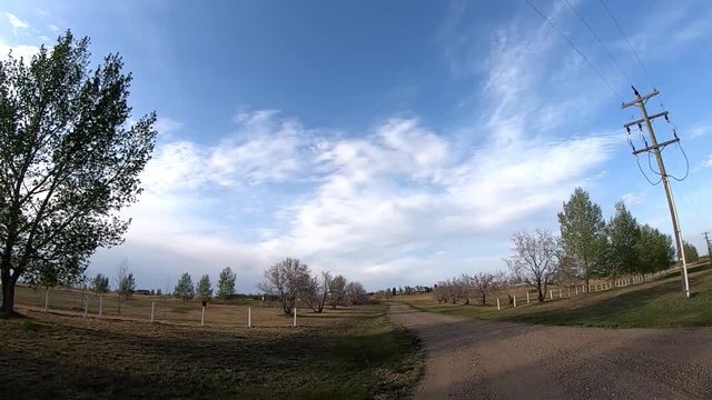 A dirt path that travels into a field in a small town in Alberta Canada.