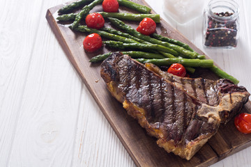Grilled T-bone steak with asparagus and cherry tomatoes