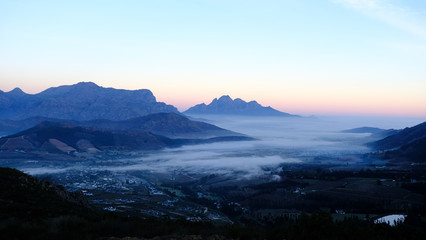 Fototapeta na wymiar Early morning view of sunrise over Franschhoek town, South Africa with mist