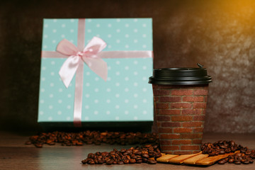 Paper cup for coffee. Grains lie on a wooden surface.