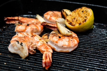 barbecued prawns in a griddle pan cooked with lemon and garlic