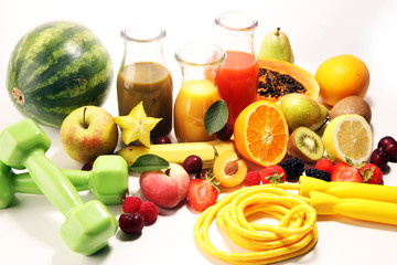 Healthy lifestyle concept. healthy fruits, smoothies and sport fitness equipment, dumbbells and jumping rope
