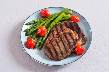 Grilled beef steak ribeye with cherry tomatoes and asparagus