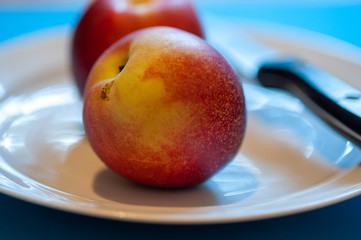 Nectarine on plate with knife