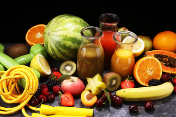 Healthy lifestyle concept. healthy fruits, smoothies and sport fitness equipment, dumbbells and jumping rope