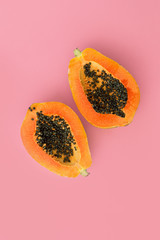 Half cut papaya on color background