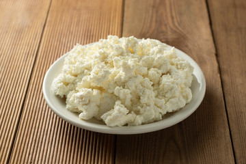 Cottage cheese isoalted on wooden background. Dairy products, calcium and protein. Healthy breakfast.