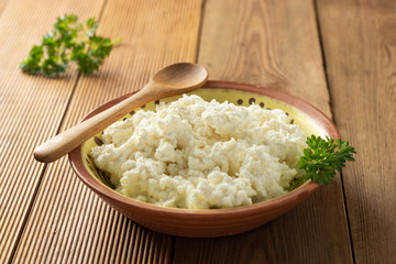 Cottage cheese isoalted on wooden background. Dairy products, calcium and protein. Healthy breakfast.