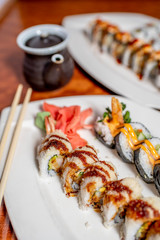 Sushi Rolls Up-Close on a White Plate with Chopsticks and Soy Sauce