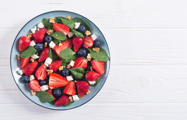 Summer Strawberry salad with spinach , cheese , nuts and blueberry