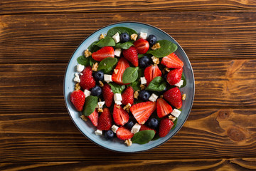 Summer Strawberry salad with spinach , cheese , nuts and blueberry