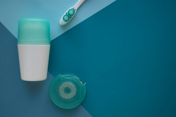 Cotton buds for ears and pads for face on blue background. A deodorant with cover of turquoise...