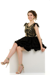 Naklejka premium Teenage girl posing studio on a white cube.
