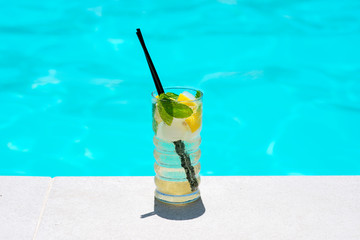 Mojito cocktail at the edge of a resort pool.
