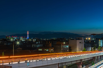 Colorful Kyoto Tower at night. Kyoto city skyline from above at dusk.