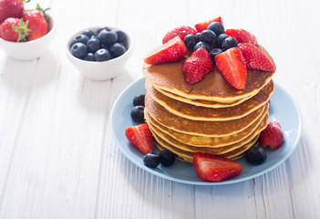Tasty pancakes with blueberry and strawberry