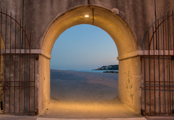An evening in Antibes, France. The sea view from a gate at the harbor