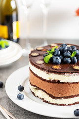 Belgian Chocolate Layered Gateau. Layers of moist choco sponge, vanilla cream and indulgent dark chocolate mousse glazed with rich dark chocolate sauce and hand decorated with fresh blueberries