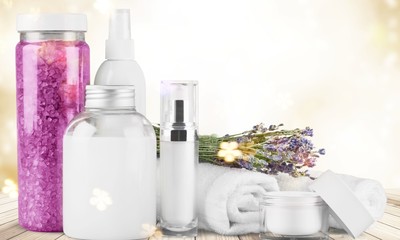 Cosmetic containers and flowers isolated on white