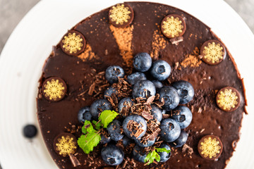 Belgian Chocolate Layered Gateau. Layers of moist choco sponge, vanilla cream and indulgent dark chocolate mousse glazed with rich dark chocolate sauce and hand decorated with fresh blueberries