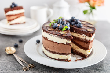 Belgian Chocolate Layered Gateau. Layers of moist choco sponge, vanilla cream and indulgent dark chocolate mousse glazed with rich dark chocolate sauce and hand decorated with fresh blueberries