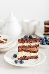 Belgian Chocolate Layered Gateau. Layers of moist choco sponge, vanilla cream and indulgent dark chocolate mousse glazed with rich dark chocolate sauce and hand decorated with fresh blueberries