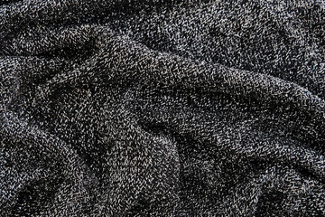 Abstract black background with splashes of silver threads, luxurious fabric or liquid. Waves or wavy folds as background or texture.