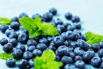Fresh Blueberries on blue background, top view. Juicy wild forest berries, bilberries. Healthy eating or nutrition