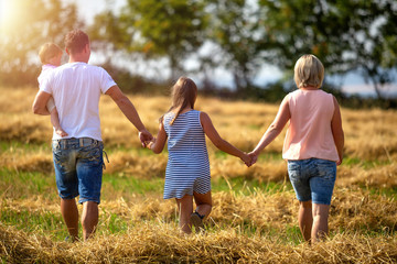 Fototapeta premium Familie spazieren Feld Sonnenuntergang
