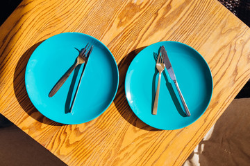 sets with empty plate, fork and knife on table. top view.
