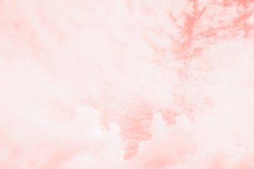 Pink coral color sky background with white clouds. Coral background