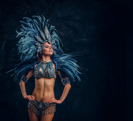 Happy brasil dancer is posing for photographer. She is wearing blue feather costume.