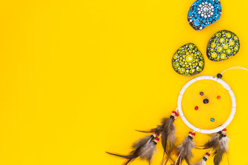 Dreamcatcher with brown bird feathers, and with threads and beads of rope hanging. Dreamcatcher...