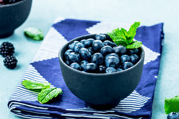Fresh Blueberries on blue background, top view. Juicy wild forest berries, bilberries. Healthy eating or nutrition