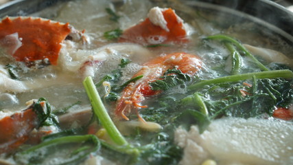 Fototapeta na wymiar Boiling seafood soup with shrimps, crabs, clams and vegetables cooked in Jagalchi fish market in South Korea in Busan.