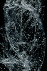 Transparent plastic wrap on the black background. Plastic bag texture. Reusable trash and waste.