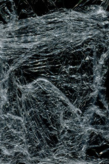 Transparent plastic wrap on the black background. Plastic bag texture. Reusable trash and waste.