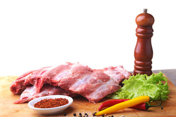 Raw Ribs on a rustic cutting board with salt, pepper and grinder for spices . White Background for copy space. Top View.