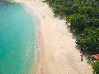 Aerial view of an amazing white sandy beach with turquoise water in tropical country. Amazing top view of sandy tropical beach. holiday destination. Palm and tropical beach with crystal clear water.
