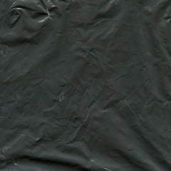 Transparent plastic wrap on the black background. Plastic bag texture. Reusable trash and waste.