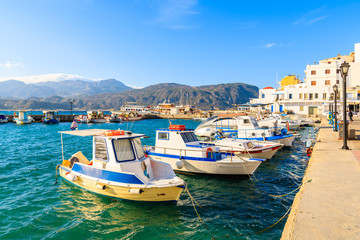 Fishing boats in picturesque Pigadia port on Karpathos island at sunset time, Greece