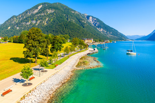View of beautiful Achensee lake and boats on sunny summer day with blue sky, Karwendel mountain range, Tyrol, Austria
